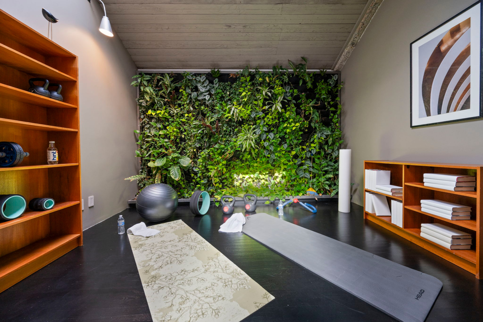 Small side room with a full-height living plant wall, mats and shelving